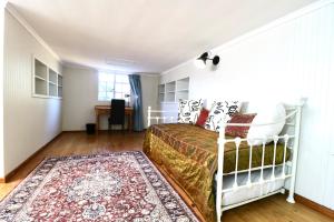 a bedroom with a bed and a rug at Cottage on 10th in Gqeberha