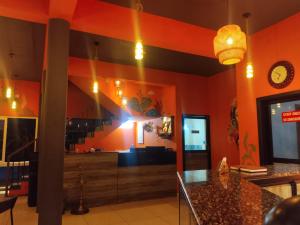 a restaurant with orange walls and a counter top at cascade island in Kollam