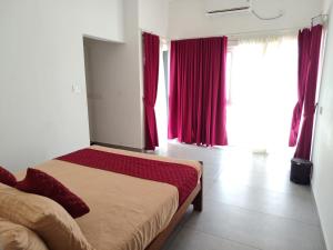 a bedroom with a bed with red curtains and a window at cascade island in Kollam