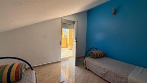 a room with two beds and a blue wall at Casa Dina in Ksar es Sghir