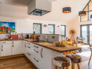 a kitchen with a wooden counter top and some windows at Strathspey Lodge in Duthil
