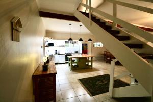 a kitchen and a living room with a staircase at Cottage on 10th in Gqeberha +12 photos