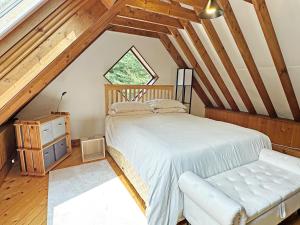 a attic bedroom with a bed and a window at The Loft House in Canford Magna +6 photos