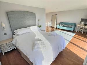 a bedroom with a large white bed and a blue couch at Barn Owl Cottage - Uk48510 in Kirk Hammerton +11 photos