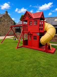a red play house with a yellow slide at Holywell Grange Farm in Whitley Bay