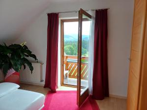 a room with a mirror and a balcony with red curtains at APARTMENT Eva in OBDACH in Obdach