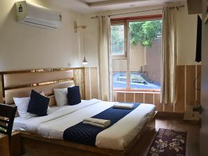 a bedroom with a large bed with a window at Jungle by sturmfrei Agra in Agra