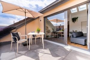 eine Terrasse mit Tisch, Stühlen und Sonnenschirm in der Unterkunft Soley70 in Neumarkt in der Oberpfalz
