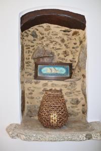 a stone fireplace with a basket in front of it at Aethra Seaview Suites in Kerames