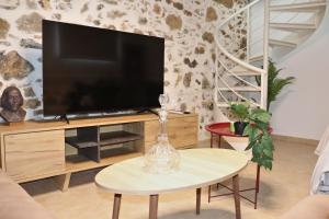 a living room with a tv and a table at Aethra Seaview Suites in Kerames