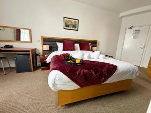 a hotel room with a large bed with flowers on it at Maya Hotel in Luton