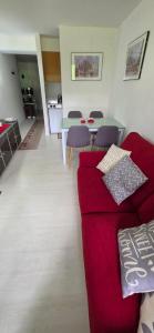 a living room with a red couch and a table at Casa Preziosa Cielo Alto in Breuil-Cervinia