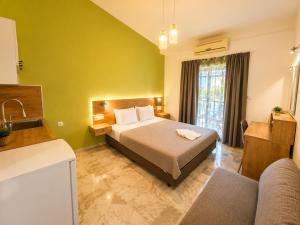 ein Schlafzimmer mit Bett, Sofa und Waschbecken in der Unterkunft Hotel Marti Studios in Skala Sotiros