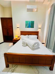 a bedroom with a large bed with towels on it at JG Luxury Hotel in Dodoma