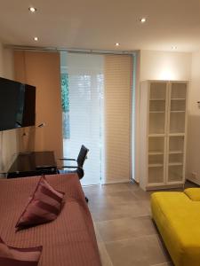 a living room with a couch and a desk and a television at Brenzapartments Heidenheim in Heidenheim an der Brenz