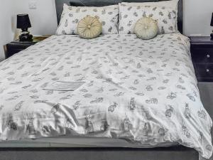 a bed with a white comforter and pillows at Cairn View in Strachan