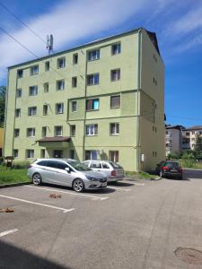 two cars parked in a parking lot in front of a building at Morrison Home Covasna in Covasna