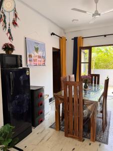 a kitchen with a dining room table and a refrigerator at Villa La Vida in Talpe