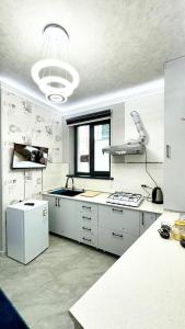 a large kitchen with white cabinets and a window at Centre Cheap Hotel in Tashkent