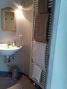 een badkamer met een wastafel en een handdoekenrek met handdoeken bij Le Temps d'une Pause in Ny
