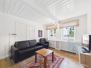 a living room with a black couch and a table at Min aran in Oevenum