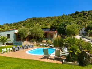 eine Villa mit Swimmingpool und Liegestühlen in der Unterkunft Hotel Marti Studios in Skala Sotiros
