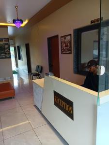 a man sitting at a reception counter in a restaurant at THE GK Resort in Ābu Road