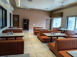 a restaurant with tables and chairs and brick walls at THE GK Resort in Ābu Road