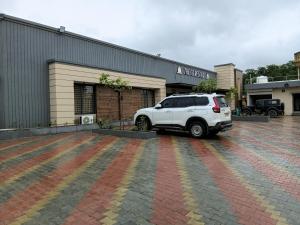 a white suv parked in front of a building at THE GK Resort in Ābu Road