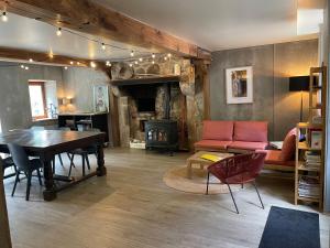 a living room with a table and a fireplace at Le Moulin de St André in Saint-André-en-Morvan