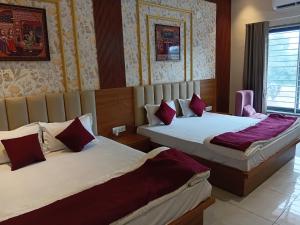two beds in a hotel room with two beds at THE GK Resort in Ābu Road