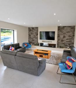 a living room with two couches and a flat screen tv at Sea Mourne View in Carlingford