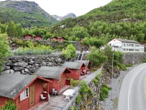 a row of red cabins on a hill next to a road at Hellesylt Hostel in Hellesylt