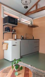 a kitchen with a white refrigerator and a sink at Klein huisje in het centrum in Apeldoorn