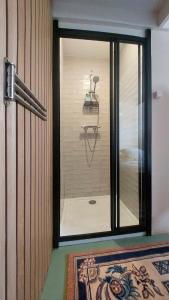 a glass door to a room with a shower at Klein huisje in het centrum in Apeldoorn