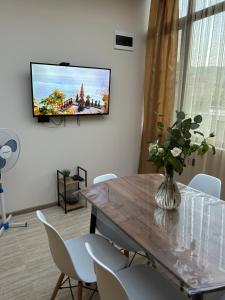 a dining room with a table and a tv on the wall at Linet Apartament in Goris