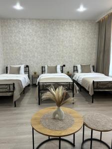 a room with two beds and a table with a vase at Linet Apartament in Goris