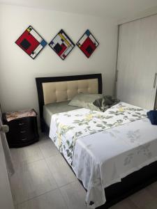 a bedroom with a bed and some pictures on the wall at Descanso Ideal in Manizales