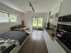 a bedroom with a bed and a living room at Moderne 1-Zimmer-Gästewohnung im Neubau mit schönem Garten in Pronstorf