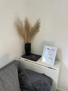 a table with a vase with feathers on top of it at Moderne 1-Zimmer-Gästewohnung im Neubau mit schönem Garten in Pronstorf