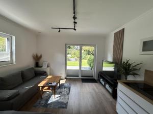 a living room with a couch and a table at Moderne 1-Zimmer-Gästewohnung im Neubau mit schönem Garten in Pronstorf