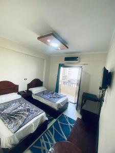 two beds in a room with a window at فندق الليدو in Marsa Matruh