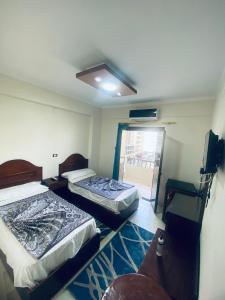 two beds in a room with a window at فندق الليدو in Marsa Matruh +2 photos