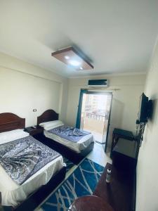 two beds in a room with a window at فندق الليدو in Marsa Matruh