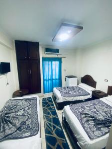 a room with three beds in a room at فندق الليدو in Marsa Matruh
