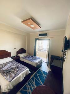 a room with two beds and a television in it at فندق الليدو in Marsa Matruh