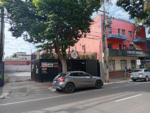 a silver car parked on the side of a street at Hotel Confort Maringá in Maringá