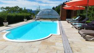 a swimming pool with umbrellas and some lounge chairs at Familienhof Kain in Tiefgraben
