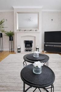 a living room with two tables and a fireplace at Rosie House 3 bedroom House in Sandbach with Parking in Sandbach