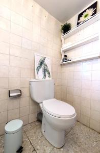 a bathroom with a toilet and some plants on the wall at Casa Ti Mielga in Ayoó de Vidriales